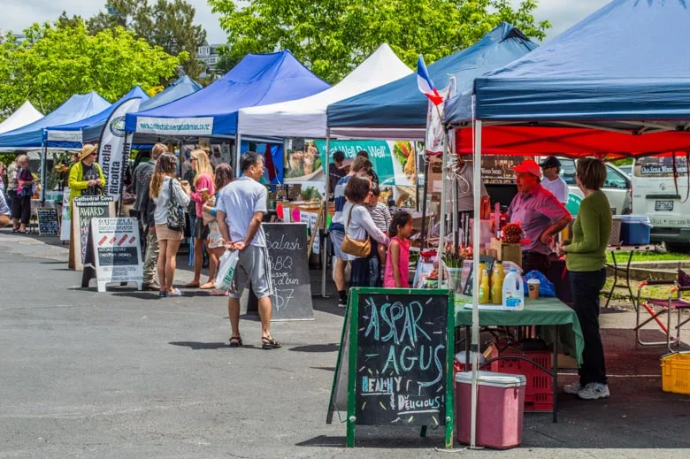 Food tent setup at farmers market with vendor and customers